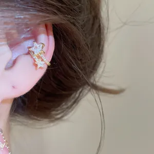 Close-up of a sparkling gold-plated star ear cuff adorned with clear zircon jewelry