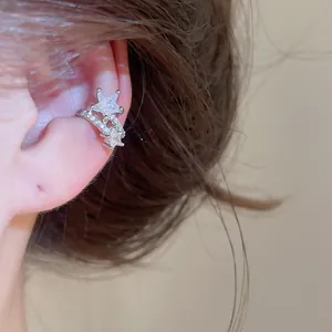 Close-up detail of silver-toned star ear cuff set with sparkling zircons