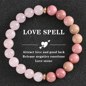Gros plan détaillé du bracelet en quartz fraise rose avec le texte romantique LOVE SPELL