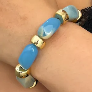 Detailed view of blue and white marble resin bead bracelet with gold accents.