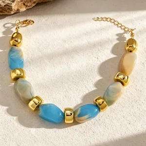 Close-up of blue and cream marbled resin bead bracelet with gold spacers