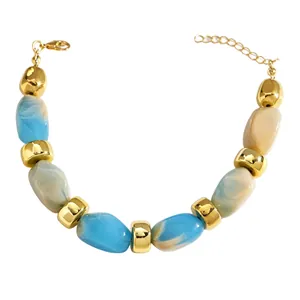 Detail showing the blue and white marbled resin beads and gold spacers on a beachy bracelet