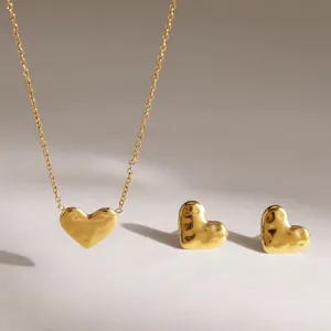 Close-up of golden hammered heart necklace and earring set in stainless steel