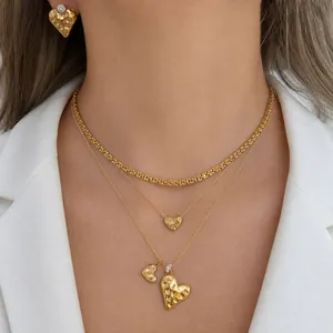 Detailed close-up of gold stainless steel layered necklaces with hammered heart charms
