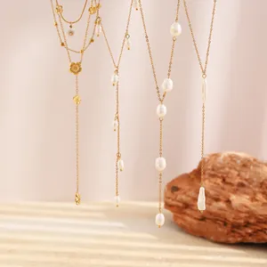 Detailansicht eleganter goldener Y-Halsketten mit zarten Perlen und Blumenanhängern