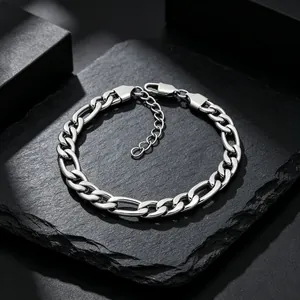 Vue macro détaillée d'un bracelet à chaîne Figaro en acier inoxydable sur une pierre noire