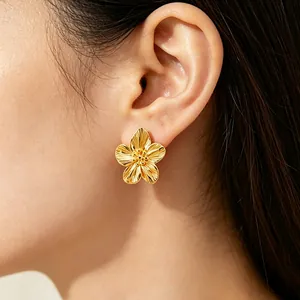 Dettaglio di un orecchino a fiore placcato oro 18K con petali testurizzati su modella