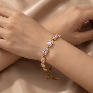 Detail eines goldenen Vintage-Armbands mit rechteckigen rosa Zirkoniasteinen und Halo-Fassung