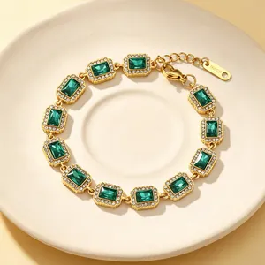 Detaillierte Makroansicht eines vergoldeten Vintage-Armbands mit smaragdgrünen Kristallen