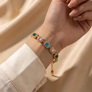 Nahaufnahme eines goldenen Vintage-Armbands mit bunten Zirkonia auf Satinhintergrund.