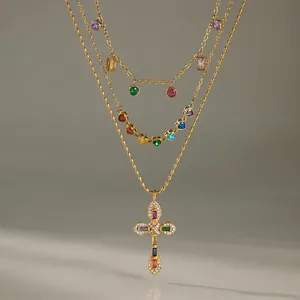 Vue détaillée d'un collier doré à plusieurs rangs avec un pendentif croix coloré