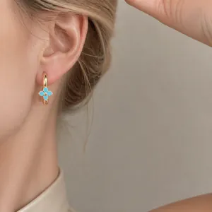 Elegant gold hoop earrings featuring a light blue zircon flower charm