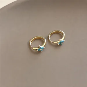 Elegant gold-plated hoop earrings featuring a dainty blue flower charm design jewelry.