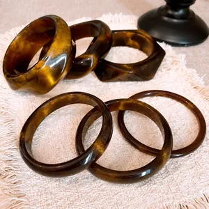 Vintage tortoiseshell resin bangles with geometric designs and elegant gold shimmer patterns.