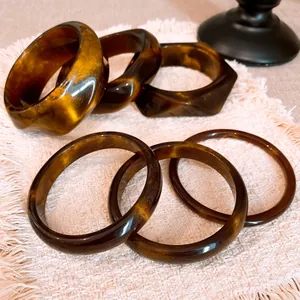 Close-up of vintage tortoiseshell resin bangles featuring chunky geometric and thin round designs