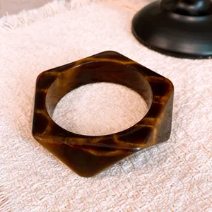 Close-up of vintage geometric resin bangle with elegant brown and gold marbled pattern