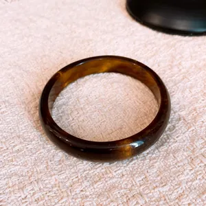 Detailed view of retro amber resin bangle with elegant marble pattern.
