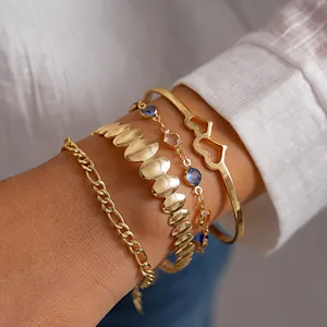 Dettaglio del set di 4 braccialetti dorati con bracciale a cuore e ciondoli in resina