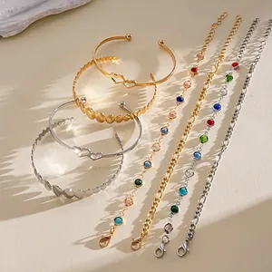 Collezione di braccialetti in oro e argento con pietre colorate e forme a cuore.