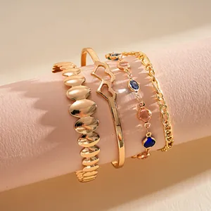 Dettaglio ravvicinato di un set di 4 bracciali in metallo dorato con cuori e pietre