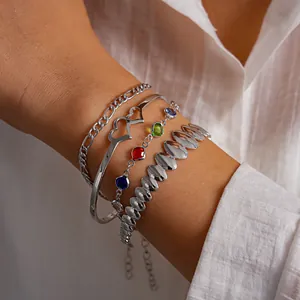 Vista dettagliata di un set di 4 gioielli argentati con bracciale a cuore e gemme colorate