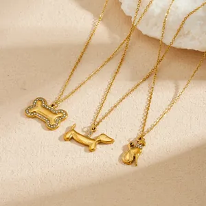 Detailed shot of three gold-plated dog-themed necklaces with rhinestone accents
