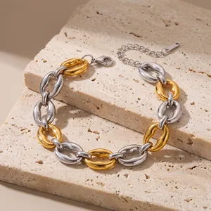 Macro detail of a chunky two-tone gold and silver stainless steel link bracelet