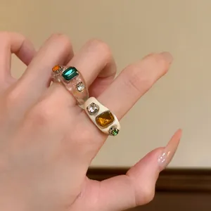 Detailed view of minimalist resin rings with sparkling colorful stones for women
