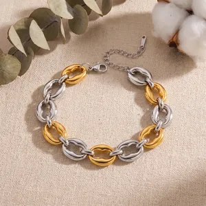 Close-up detail of bicolor stainless steel geometric chunky chain bracelet on linen
