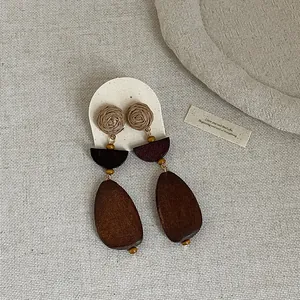 Detailed texture of bohemian retro straw woven and dark wood teardrop earrings