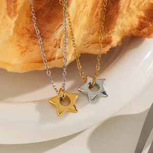 Dettaglio dei pendenti a stella in acciaio inox oro e argento su un piatto bianco