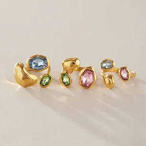 Detailansicht von organischen Goldringen mit hellblauen, grünen und rosa Glassteinen.