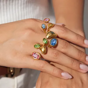 Detailansicht von bunten Glasringen mit unregelmäßigen Goldbändern an der Hand eines Models