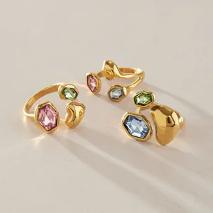 Detailansicht von drei goldenen organischen Ringen mit bunten hexagonalen Glassteinen