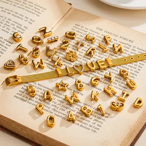Goldfarbene DIY-Anhänger aus Edelstahl mit Zirkonia-Einlagen auf einem offenen Buch