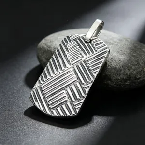 Close-up of men's titanium steel dog tag pendant featuring interlocking 3D textured ridges.