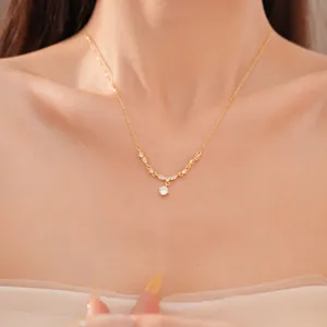 Detail shot of 18k gold plated round zircon necklace on a model's collarbone.