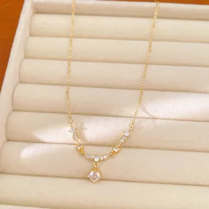 Detailed view of gold plated necklace with round zircon pendant in beige jewelry box