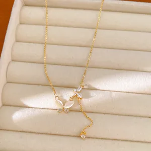 Close-up view of an elegant gold butterfly necklace with zircon and shell pendants on display