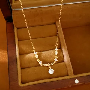 Close-up of 18k gold plated necklace with sparkling zircon pendant in wooden box