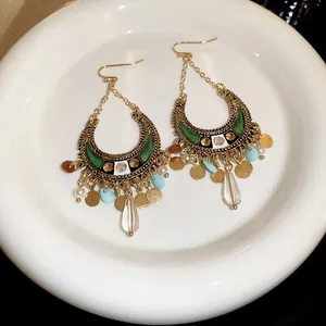 Vue macro de boucles d'oreilles bohèmes avec cristaux colorés et design de croissant vintage