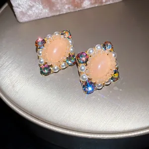 Gros plan détaillé de boucles d'oreilles vintage bohèmes avec pierres pêche et cristaux