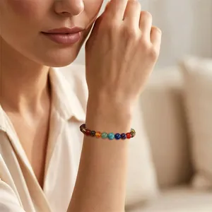 Detailed view of an 8mm seven chakra natural stone healing bracelet on a female wrist
