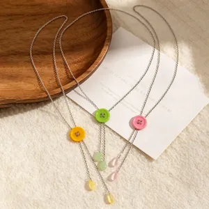 Detail van macaron knop Y-ketting met kleurrijke waterdruppel kwastjes aan de ketting