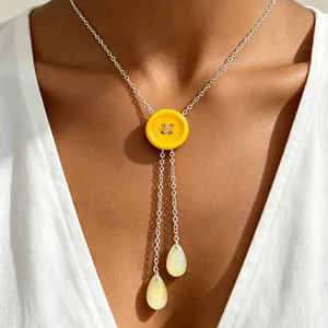Gedetailleerd beeld van een gele knoop Y-ketting met elegante druppelkwastjes