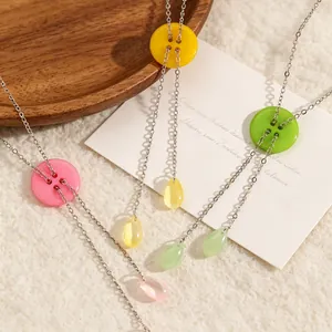 Detailopname van macaronkleurige knoop en waterdruppel hangers aan Y-vormige ketting