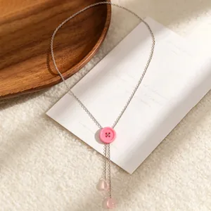 Detailweergave van een roze macaron knoop Y-ketting met druppelvormige kwastjes sier