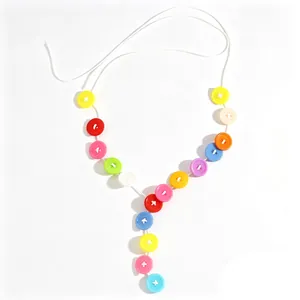 Kleurrijke macaron knop Y-vormige ketting met kwastje op een helder witte achtergrond.