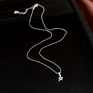 Elegante collar con colgante de estrella plateada y circón azul en negro