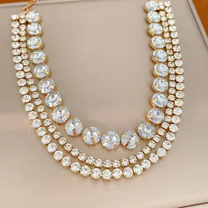 Close-up of a glamorous three-layer gold collar necklace with sparkling round crystals.